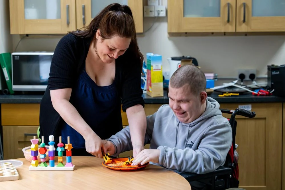 An adult and a support worker taking part in a tabletop activity